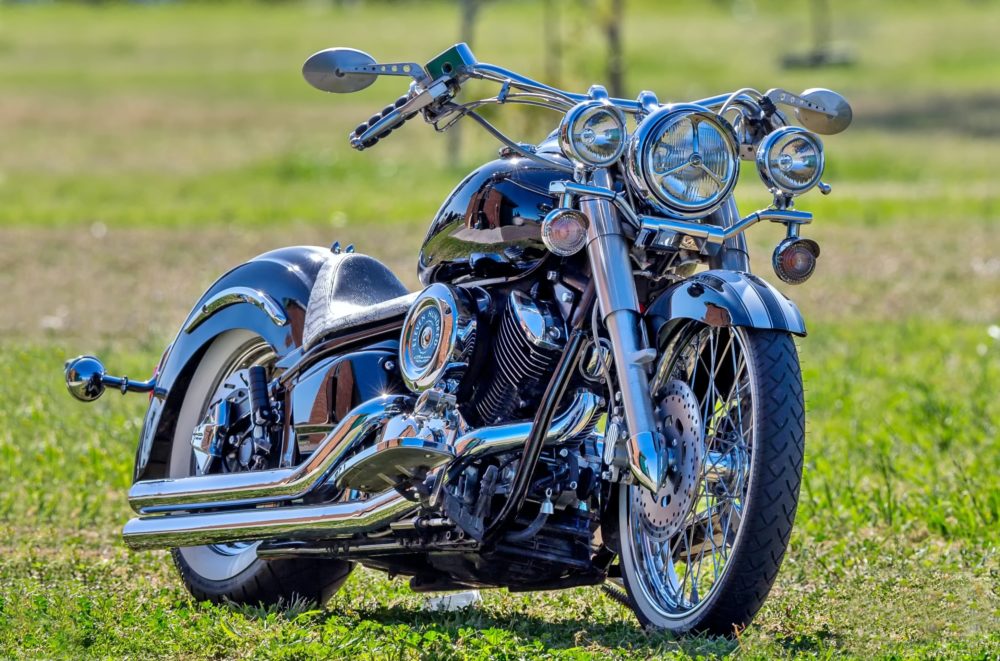 gray and black cruiser motorcycle parked at the grass fields